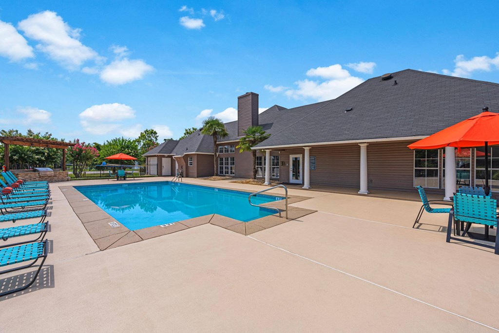 our resort style pool is next to our club house with chairs and umbrellas