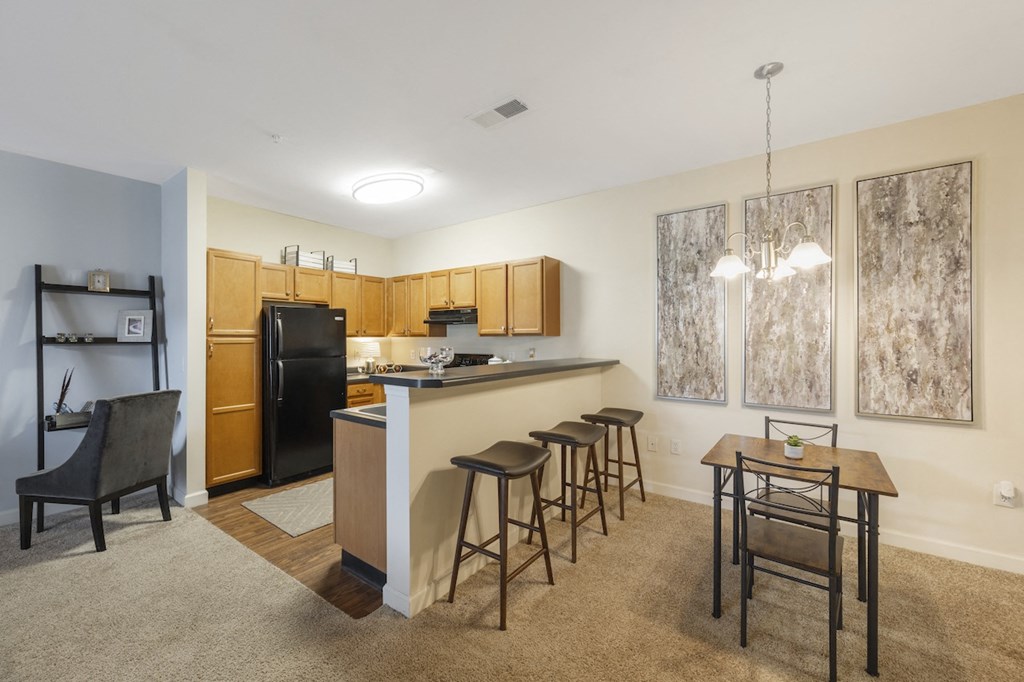 a kitchen with a bar and a dining room with a table and chairs