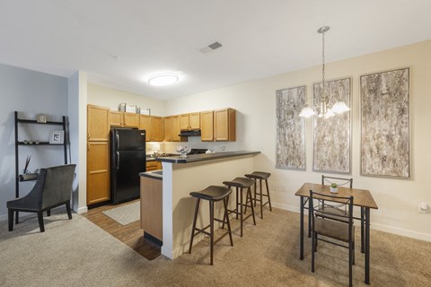 a kitchen with a bar and a dining room with a table and chairs