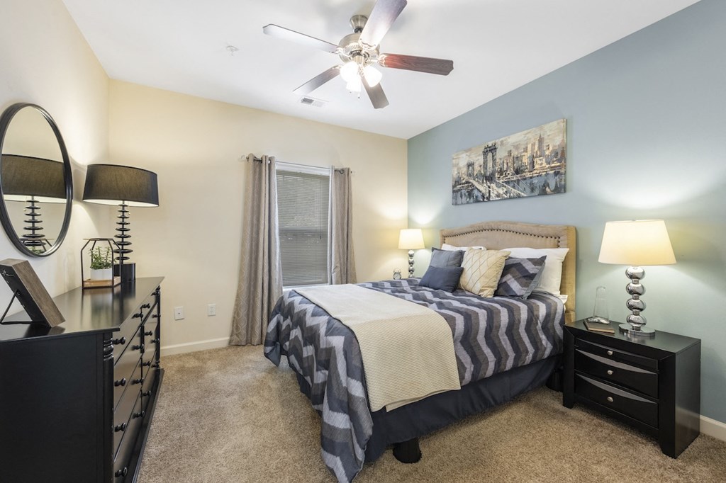 a bedroom with a bed and a ceiling fan