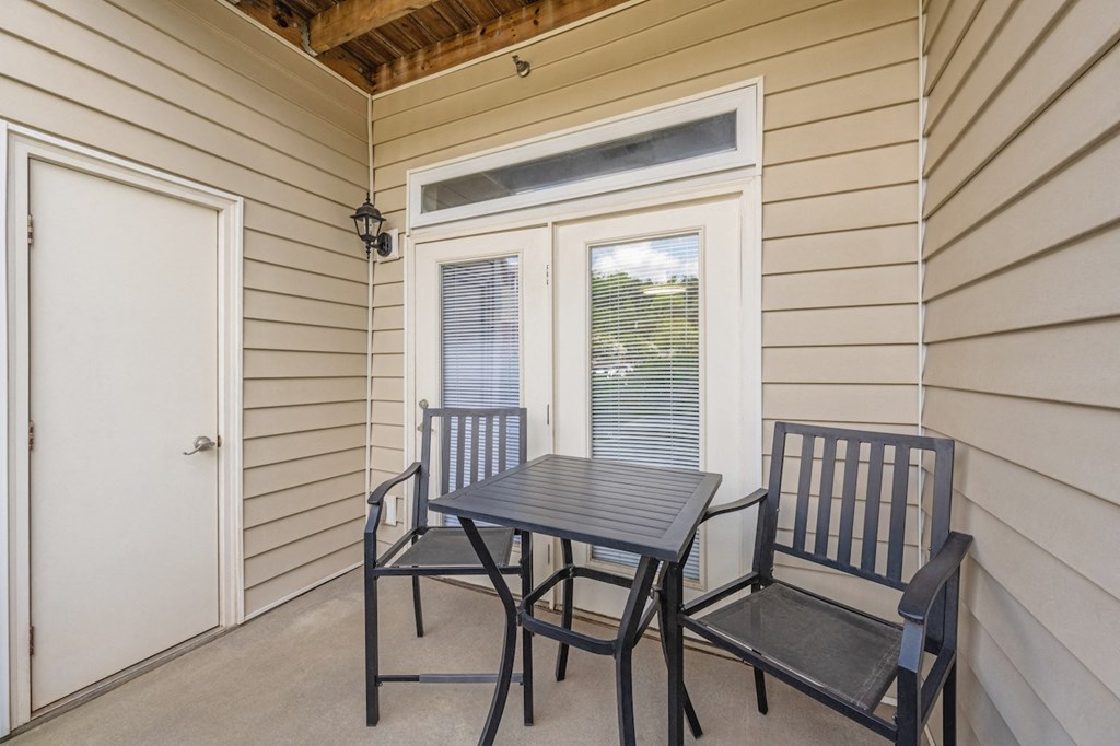 a balcony with a table and chairs and a door