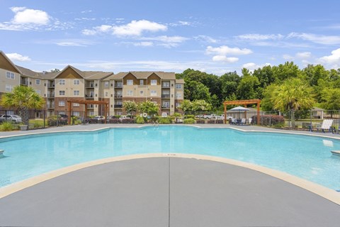 A large swimming pool in front of apartment buildings.