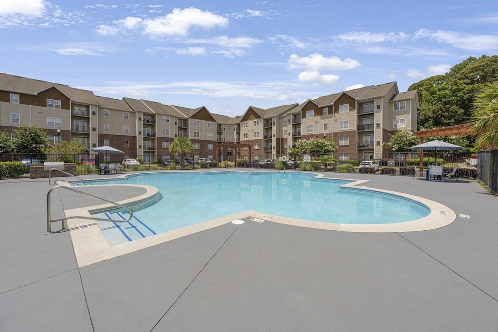 a swimming pool with an apartment building in the background