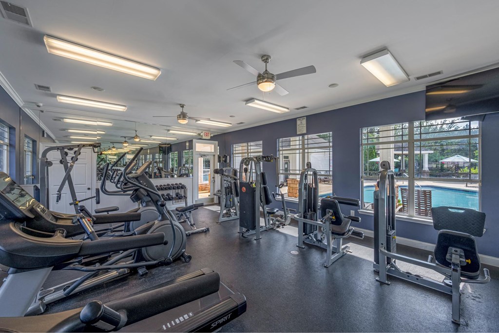 a gym with weights and cardio equipment and a pool