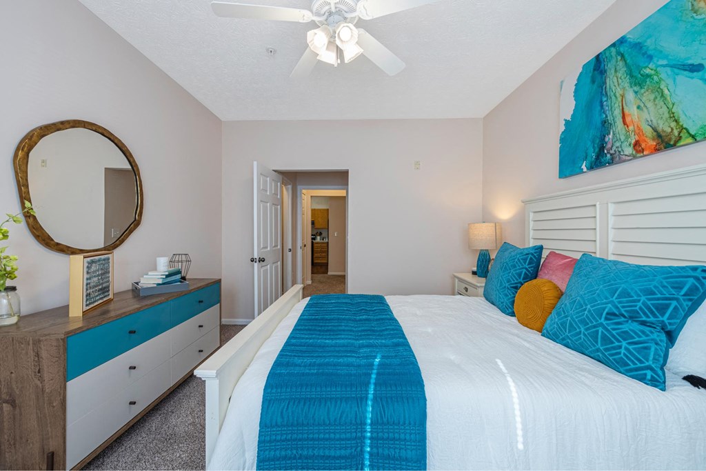 a bedroom with a large bed and a ceiling fan