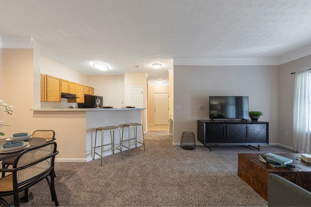 a living room with a kitchen and a table and chairs