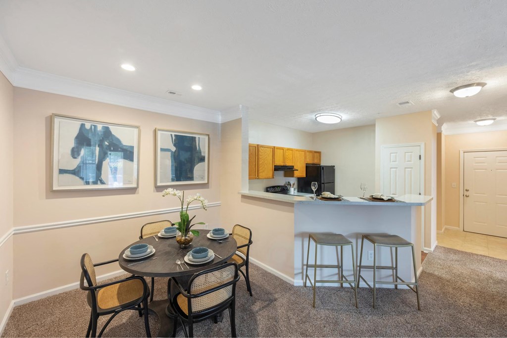 a dining room with a table and chairs and a kitchen