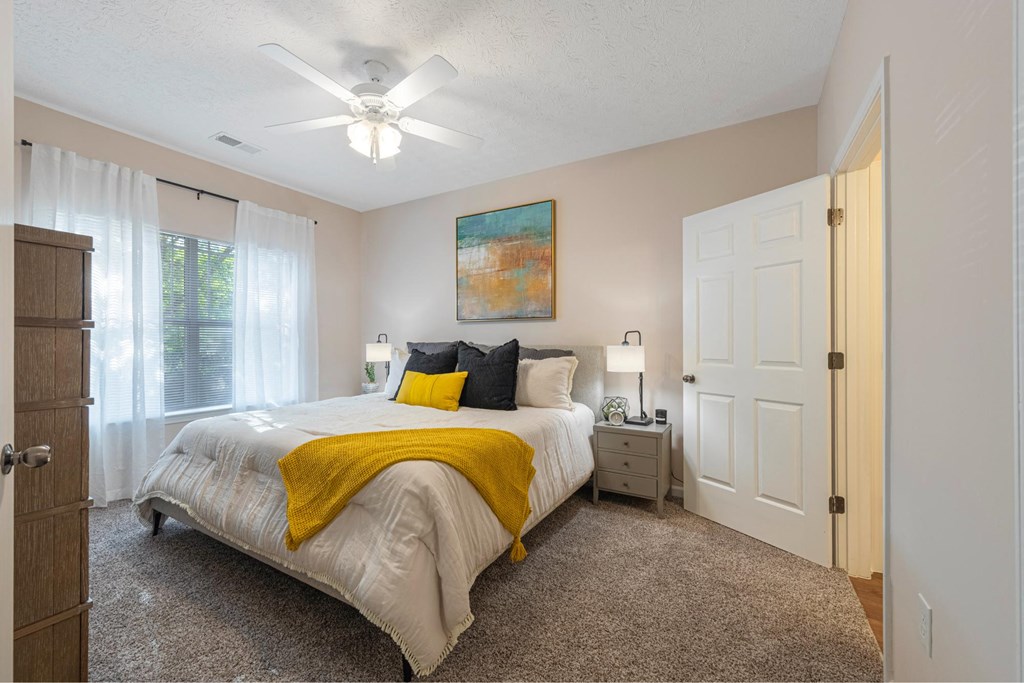 a bedroom with a bed and a ceiling fan