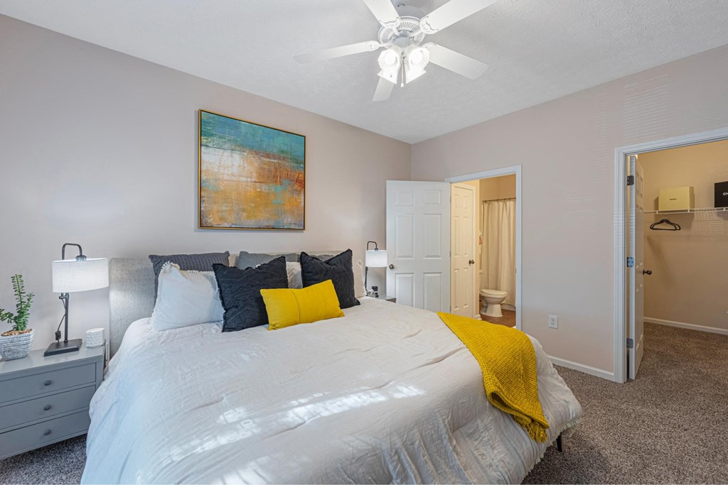 a bedroom with a large bed and a ceiling fan