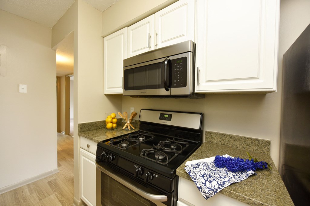 a kitchen with white cabinets and a black stove top oven