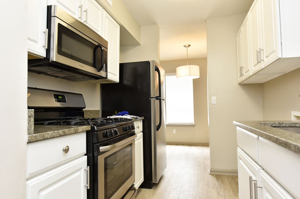 a kitchen with white cabinets and black appliances