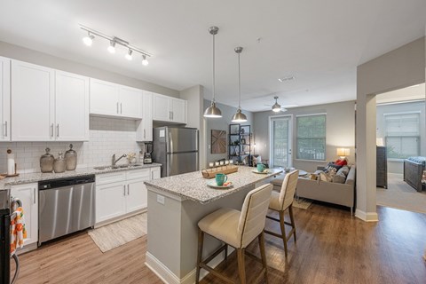 a kitchen and living room with white cabinets and a counter