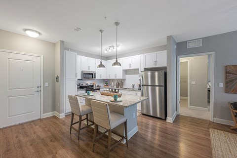 a kitchen with a large island and a stainless steel refrigerator