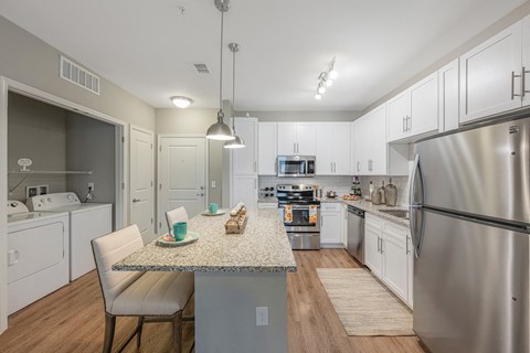 an open kitchen with stainless steel appliances and a granite counter top