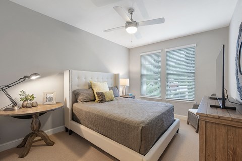 a bedroom with a bed and a ceiling fan