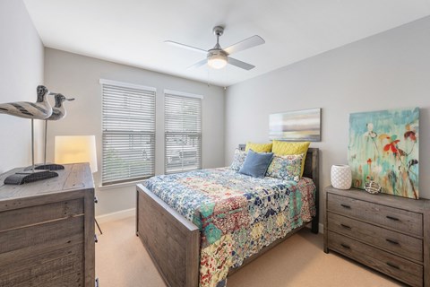 a bedroom with a bed and a ceiling fan