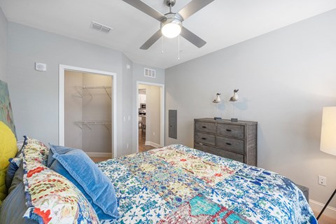 the master bedroom has a large bed and a ceiling fan