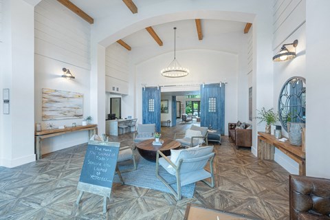 a large living room with a table and chairs and a chalkboard in the center