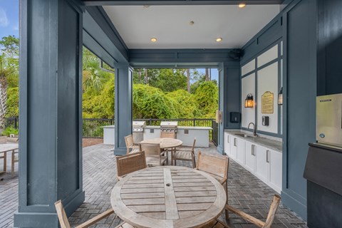 a patio with a table and chairs and a kitchen with blue walls