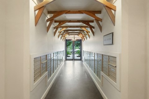 a long hallway with wooden beams and mailboxes