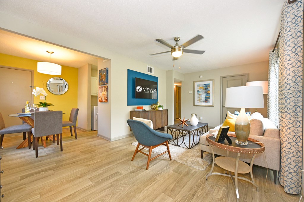 a living room with a ceiling fan and hardwood flooring