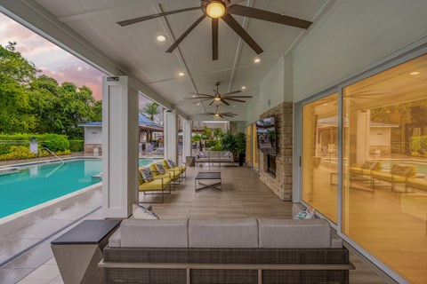 a covered patio with a pool and a ceiling fan