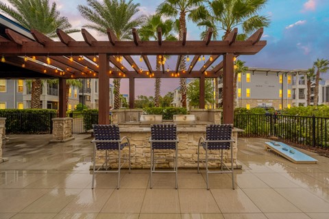 a patio with a table and chairs under a wooden pergola