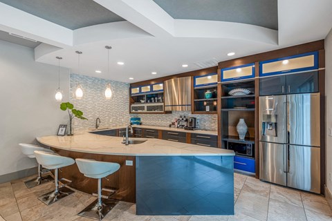 the kitchen has a large island with a breakfast bar and stainless steel appliances