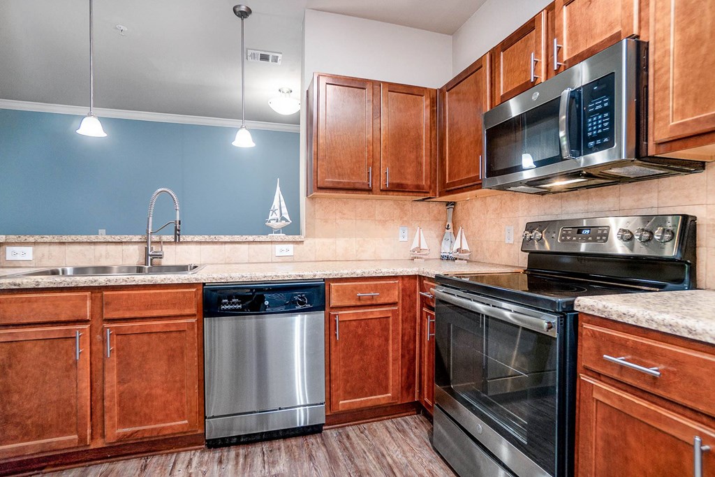 Apartments in Myrtle Beach SC - Lattitude @ The Commons - Spacious Kitchen with Stainless Steel Appliances, Woodstyle Flooring, and Matching Cabinets.