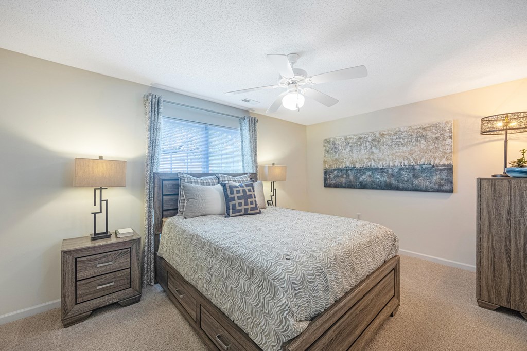 a bedroom with a bed and a ceiling fan