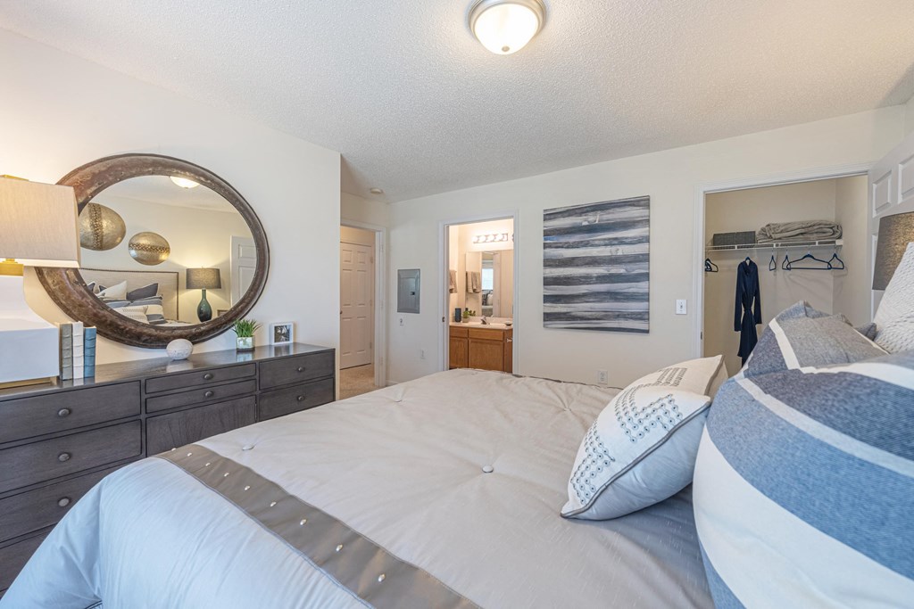 a bedroom with a bed and a mirror and a closet