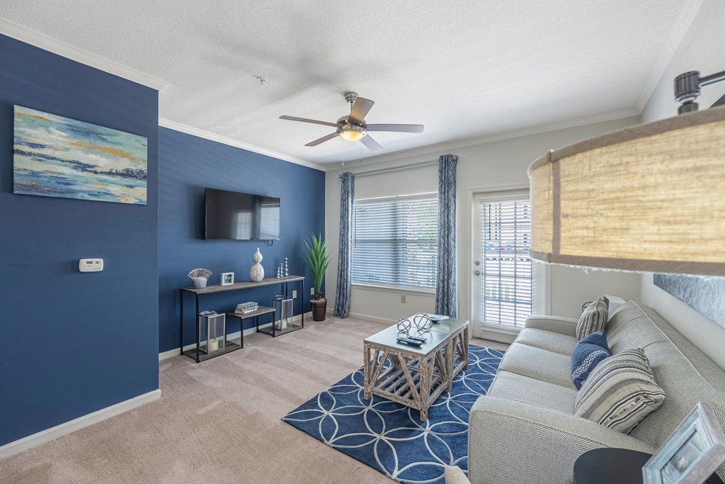 a living room with a couch and a ceiling fan