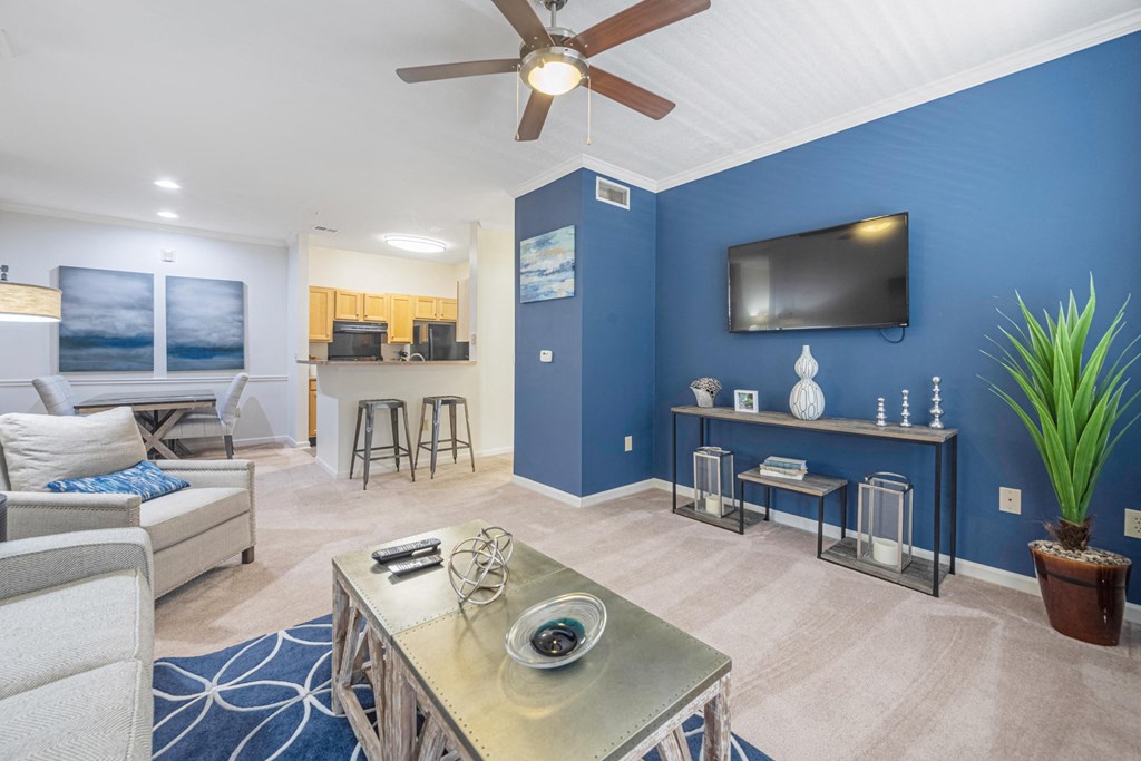 a living room with a blue wall and a ceiling fan