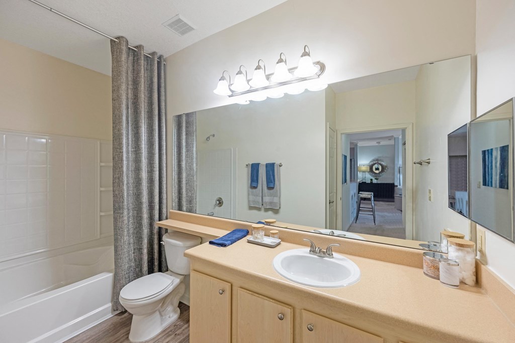 a bathroom with a large mirror and a toilet and a sink