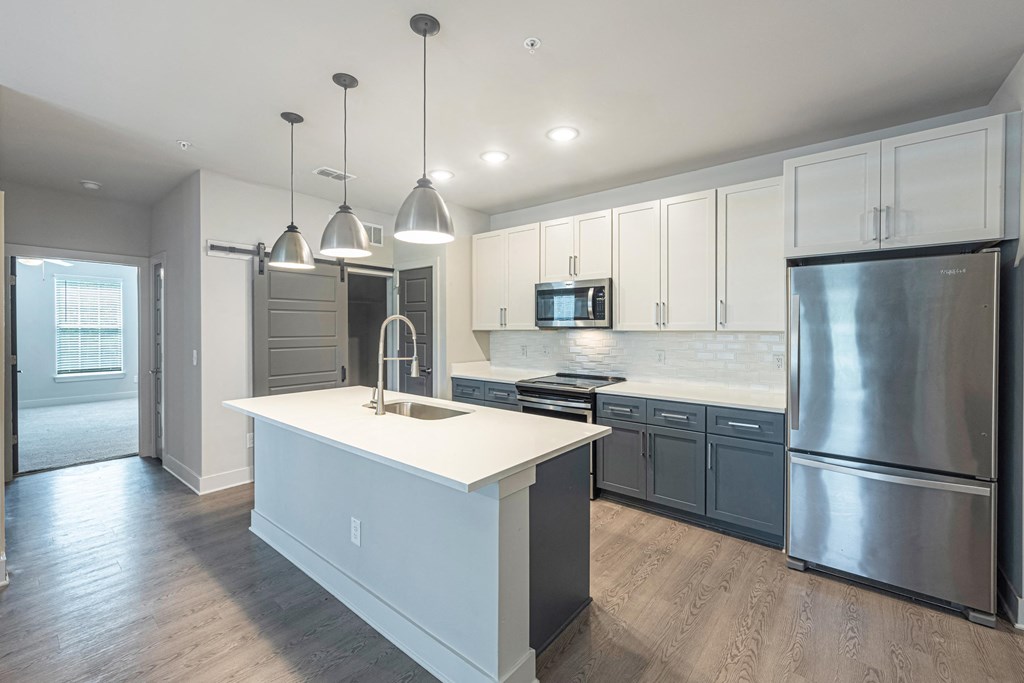 A modern kitchen with a white island and stainless steel appliances.