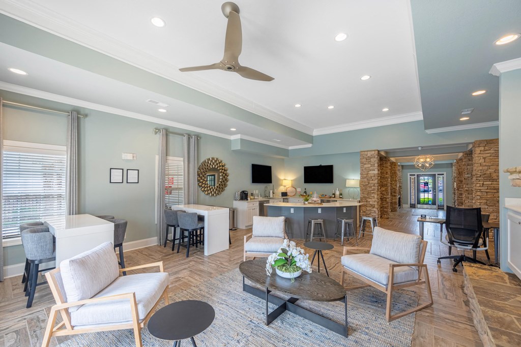 a living room with couches and chairs and a kitchen