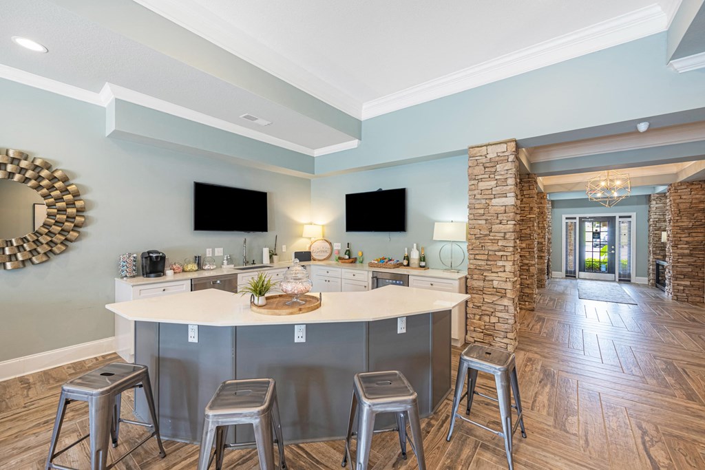 a kitchen with a large island with three stools