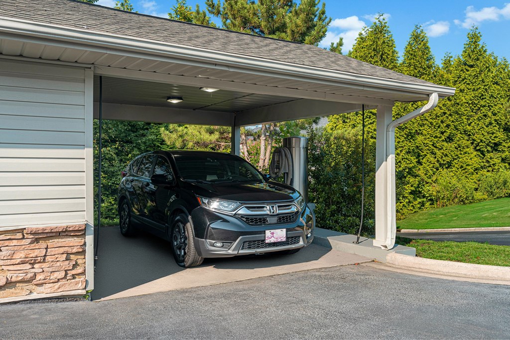 a car parked in a carport in front of a house