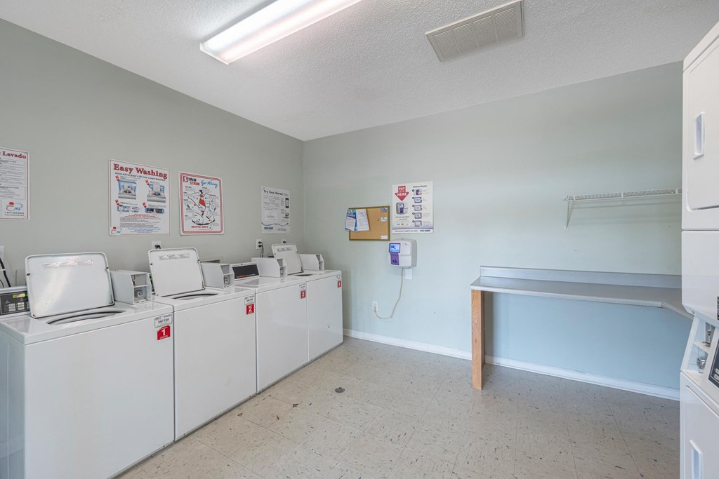 the laundry room is equipped with washes and dryers and a counter with a