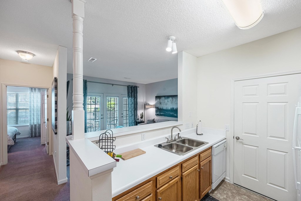 an open kitchen and living room with a sink and a window