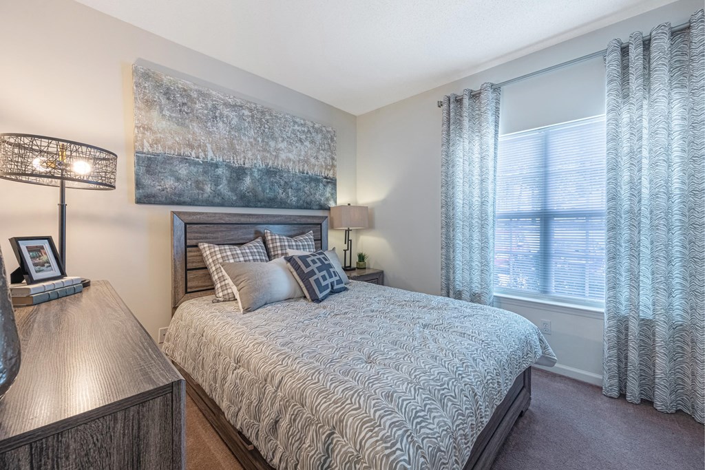 a bedroom with a bed and a large window