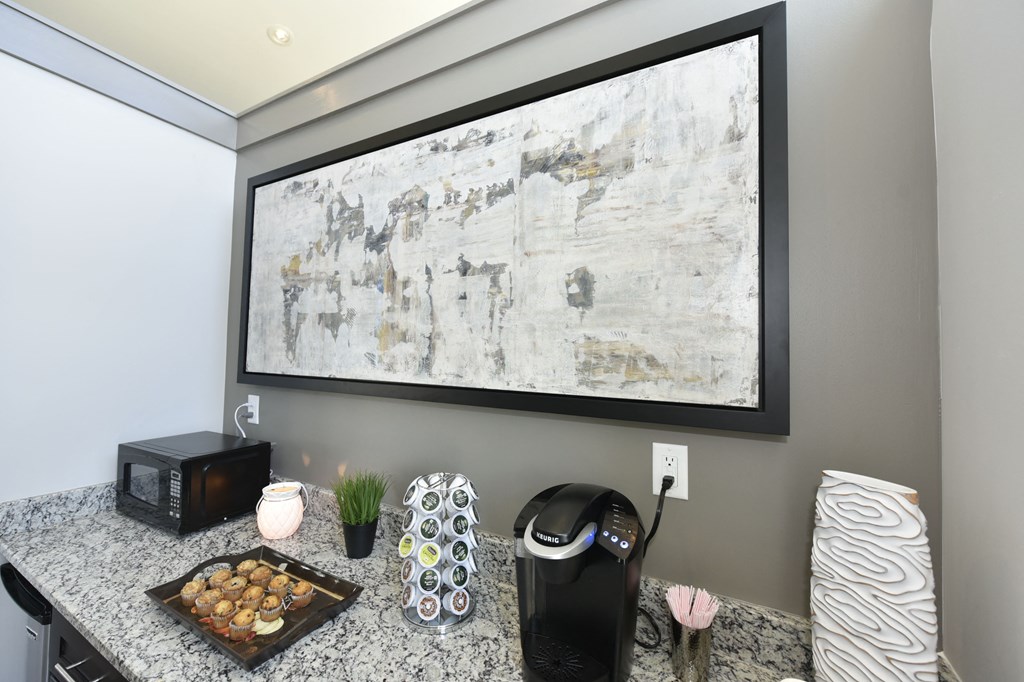 a kitchen with a counter top and a large painting on the wall