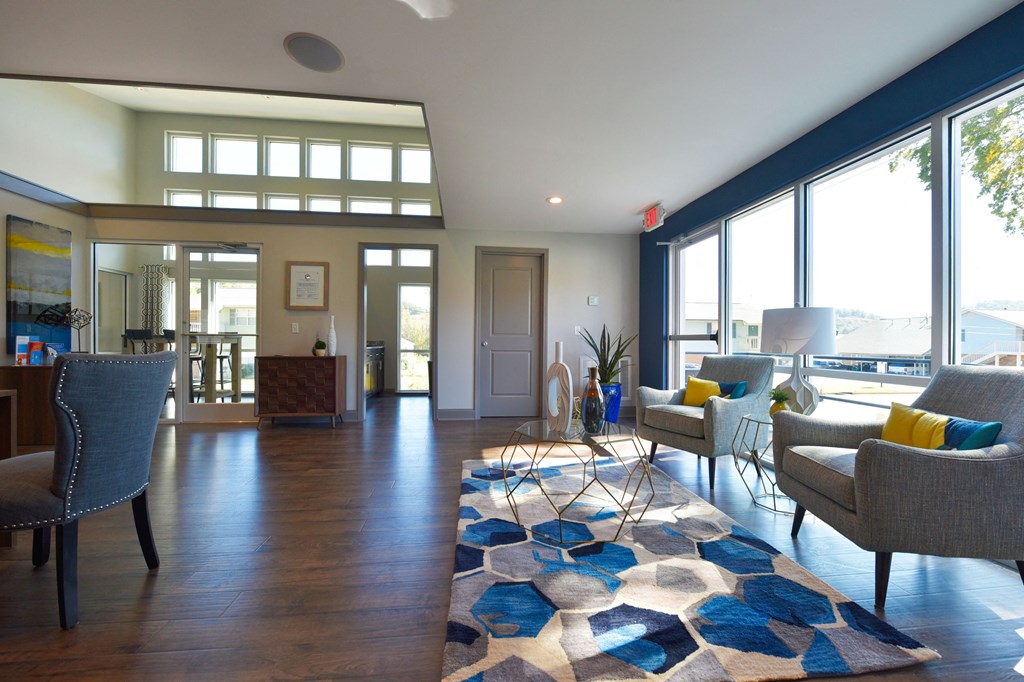 a living room with blue walls and a colorful rug