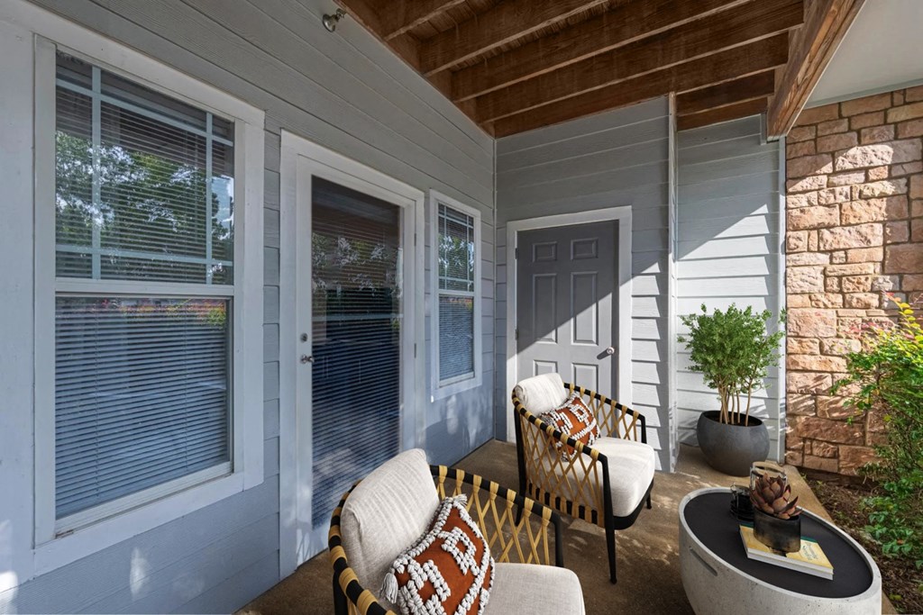 the porch of a home with chairs and a table