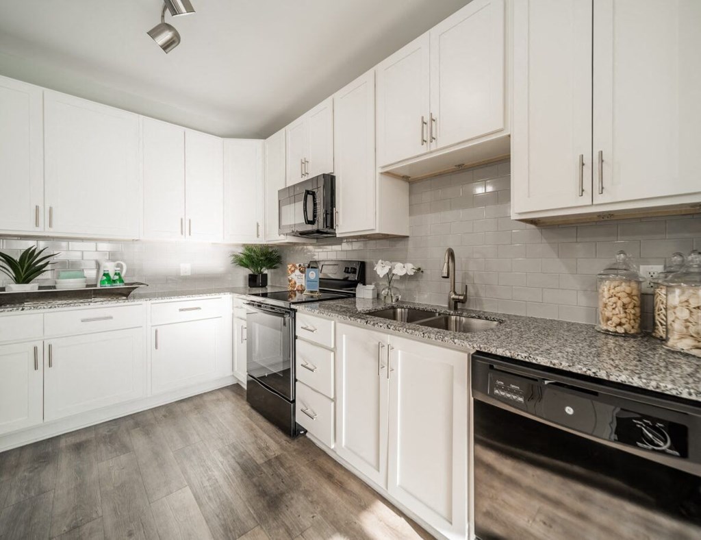 a kitchen with white cabinets and stainless steel appliances