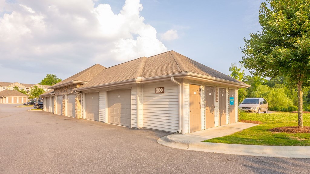 a small building with a parking lot and a car garage