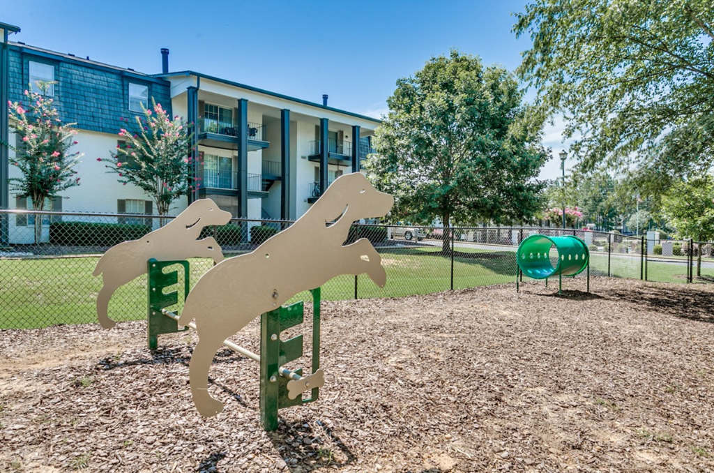 a dog park with three sculptures of dogs in front of a building