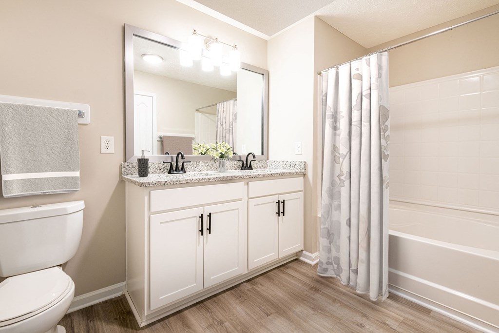 a bathroom with white cabinets and a shower and a toilet