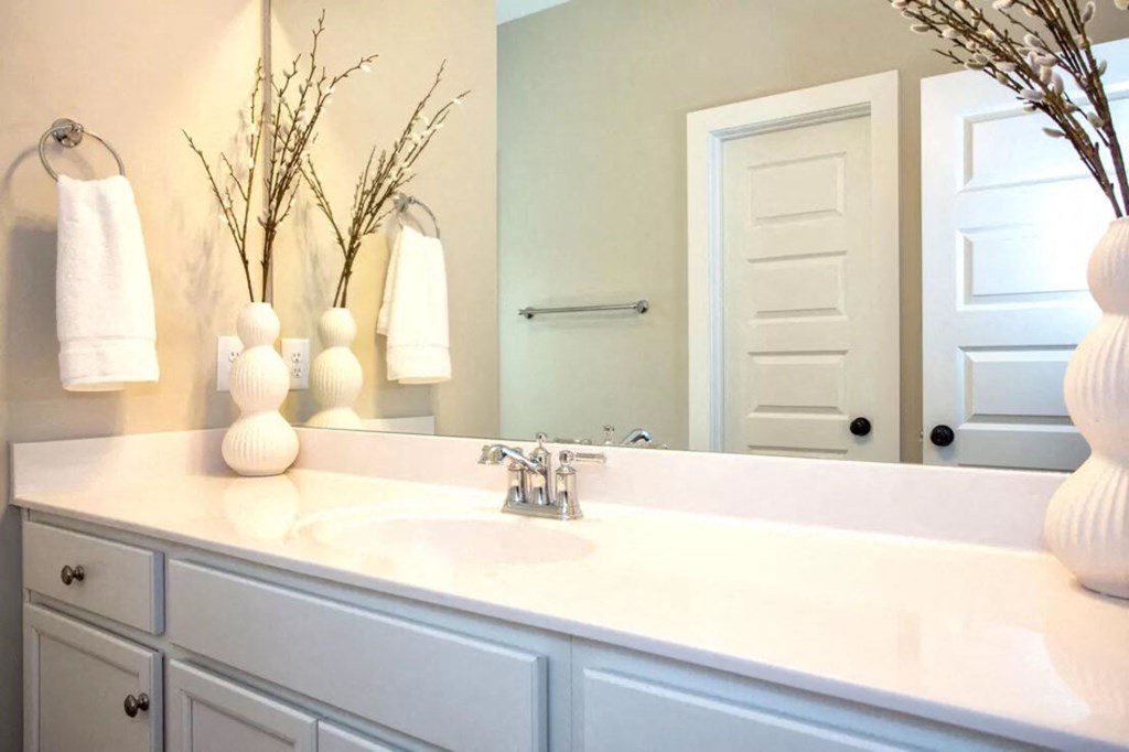 a white bathroom with a sink and a mirror