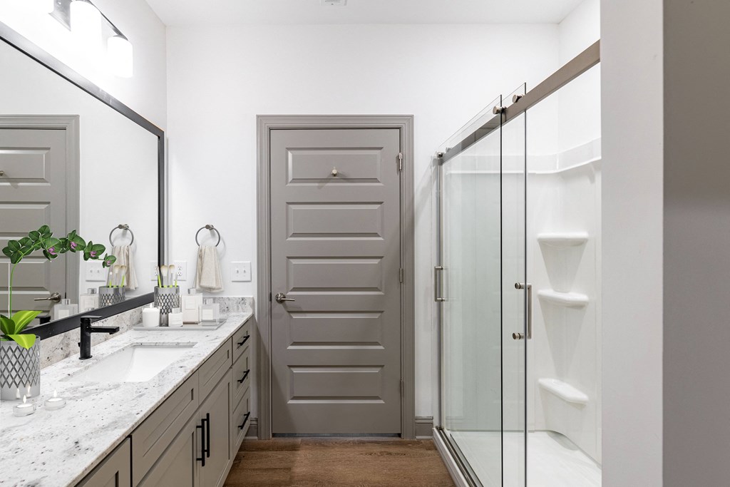 a bathroom with a sink and a shower and a door